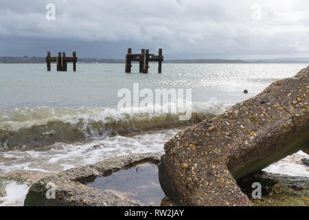 Die Reste von Strukturen aufgerufen, die Delphine im Meer weg von Lepe Strand, Teil der pierhead auf D-Tag im 2. Weltkrieg, Hampshire, Großbritannien Stockfoto