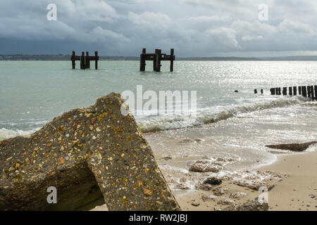 Die Reste von Strukturen aufgerufen, die Delphine im Meer weg von Lepe Strand, Teil der pierhead auf D-Tag im 2. Weltkrieg, Hampshire, Großbritannien Stockfoto