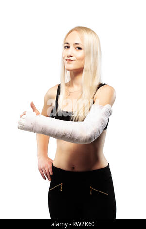 Fitness blonde Mädchen mit einem gebrochenen Arm in Gips, Daumen hoch Stockfoto