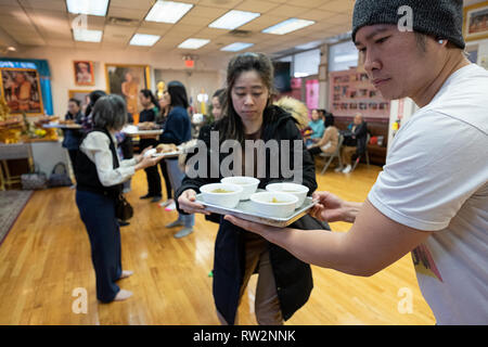 Anbeter in einem buddhistischen Tempel Form einer Montagelinie Lieferung von Nahrung vorbereitet und für ihre Mönche gekocht. In Elmhurst, Queens, New York Stockfoto