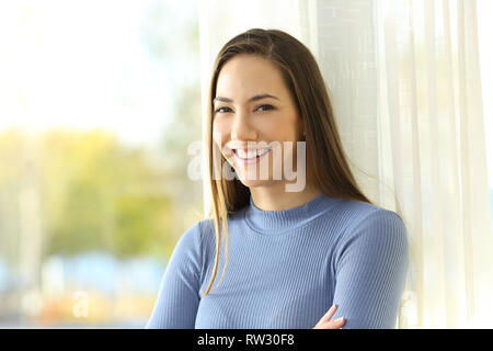 Portrait eines glücklichen Hausbesitzer an Kamera suchen neben einem Fenster zu Hause Stockfoto