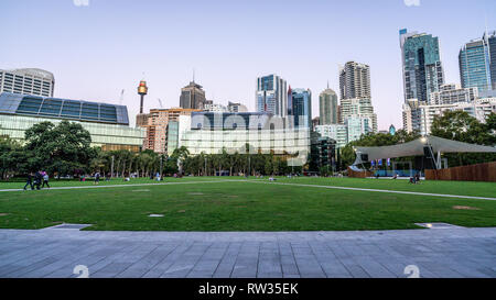 23. Dezember 2018, Sydney NSW Australien: grasbewachsenen Platz am Tumbalong Park in der Dämmerung mit Sydney Skyline im Hintergrund, im Darling Harbour NSW Australien Stockfoto