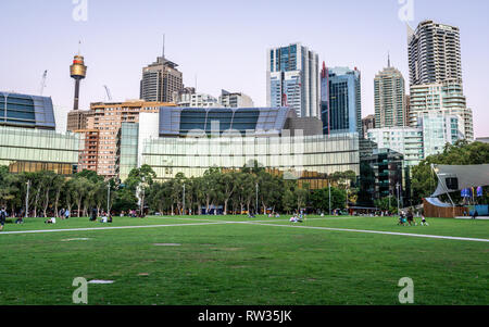 23. Dezember 2018, Sydney NSW Australien: grasbewachsenen Platz am Tumbalong Park in der Dämmerung mit Sydney Skyline im Hintergrund, im Darling Harbour NSW Australien Stockfoto