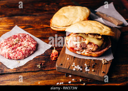 Cheeseburger auf Schneidebrett mit Rindfleisch Patty. Stockfoto