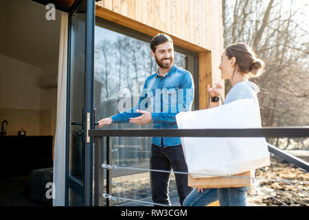 Junges Paar Eingabe home Durchführung Einkaufstüten. Gerne erwerben und modernes Leben Konzept Stockfoto