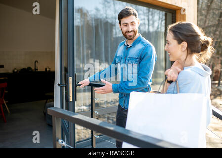 Junges Paar Eingabe home Durchführung Einkaufstüten. Gerne erwerben und modernes Leben Konzept Stockfoto