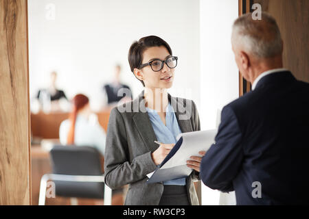 Taille bis Porträt der jungen Geschäftsfrau holding Zwischenablage Fragen beim Gespräch mit dem Chef oder Business Coach, kopieren Raum Stockfoto