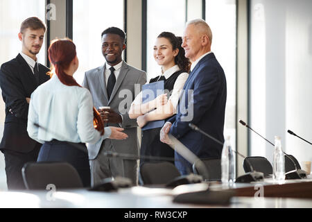 Multi-ethnischen Gruppe von fröhlichen Geschäft Leute stehen durch die Fenster im Büro und Kommunikation, kopieren Raum Stockfoto