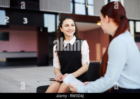 Portrait von lächelnden jungen Geschäftsfrau im Gespräch mit Kollegen in der Lobby oder im Büro Halle, Platz kopieren Stockfoto