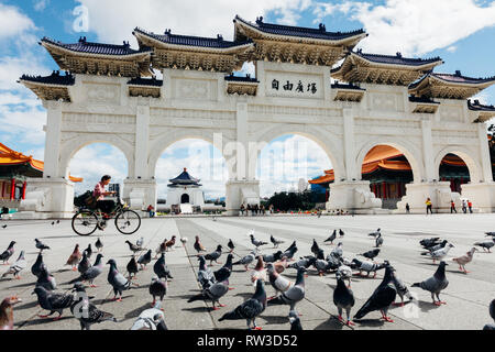 Taipei, Taiwan - November 06, 2018: Frau reitet ein Fahrrad vor der Nationalen Chiang Kai-shek Memorial Hall am November 06, 2018 in Taipeh, Taiwan​ Stockfoto