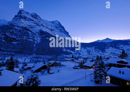 Grindelwald Dorf in der Dämmerung mit Mt. Eiger Peak im Hintergrund, Schnee, Landschaft im Winter, Schweiz Stockfoto