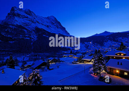 Grindelwald Dorf in der Dämmerung mit Mt. Eiger Peak im Hintergrund, Schnee, Landschaft im Winter, Schweiz Stockfoto