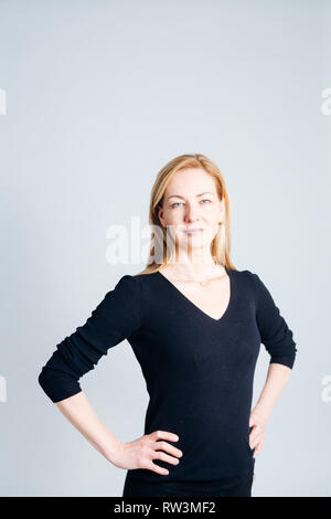 In der Nähe von Studio Portrait einer schönen Frau im schwarzen Kleid vor weißem Hintergrund Stockfoto