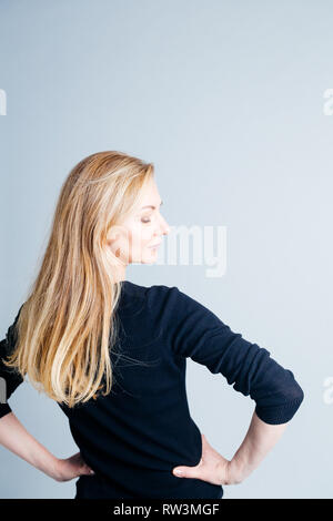 In der Nähe von Studio Portrait einer schönen Frau im schwarzen Kleid vor weißem Hintergrund Stockfoto