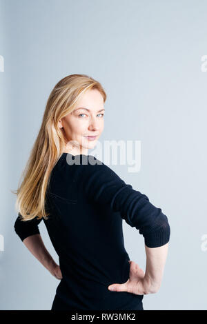 In der Nähe von Studio Portrait einer schönen Frau im schwarzen Kleid vor weißem Hintergrund Stockfoto