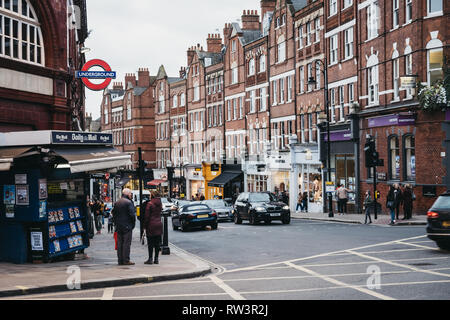 London, Großbritannien - 2. März 2019: Menschen, die von der U-Bahnstation Hampstead, London, Einzelhandel auf dem Hintergrund. Hampstead ist einer wohlhabenden Wohngegend Stockfoto