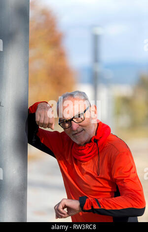 Ein gut aussehender Mann mittleren Alters im Sport einheitliche Blick auf Kamera und lächelnd Stockfoto