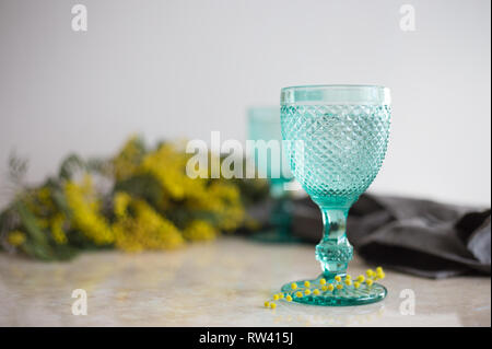 Blue Vintage Kelche und gelben Mimosen, Blumen. Weingläser auf whight Hintergrund. Stockfoto