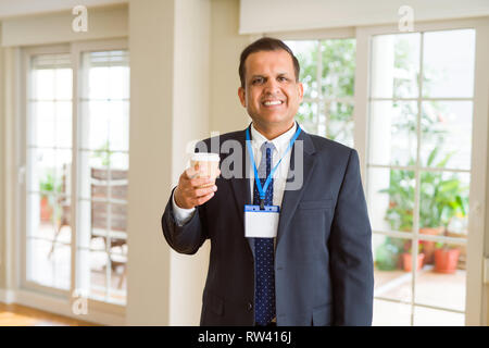Mittleres Alter Geschäftsmann, trinken eine Tasse Kaffee tragen ID-Karte Stockfoto