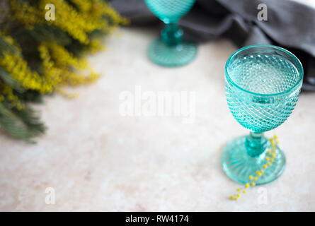 Blue Vintage Kelche und gelben Mimosen, Blumen. Weingläser auf whight Hintergrund. Stockfoto