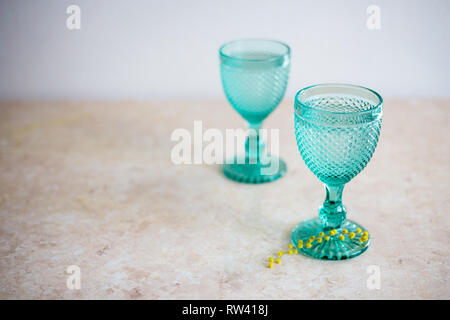 Blue Vintage Kelche und gelben Mimosen, Blumen. Weingläser auf whight Hintergrund. Stockfoto