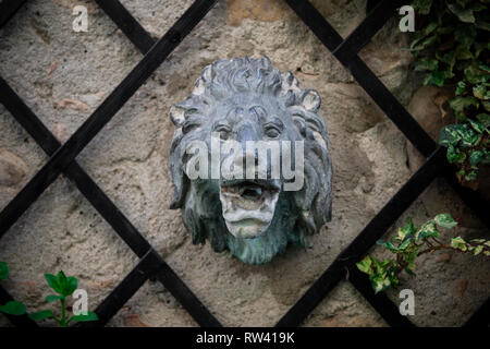 Antike cast lion's head Brunnen an der Wand mit Efeu im Garten. Rivalta schloss, Emilia Romagna, Italien. Stockfoto