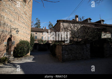 Rivalta "borgo", das mittelalterliche Dorf rund um die Burg, die mit dem Turm und einer der ursprünglichen Gebäude. Rivalta, Emilia Romagna, Italien. Stockfoto