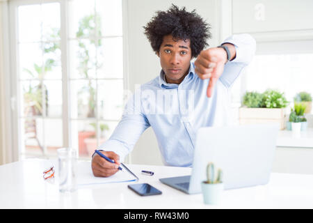 African American Business Mann schreiben auf Notebook mit Verärgerten Gesicht, negatives Vorzeichen zeigen Abneigung mit Daumen nach unten, Ablehnung Konzept Stockfoto