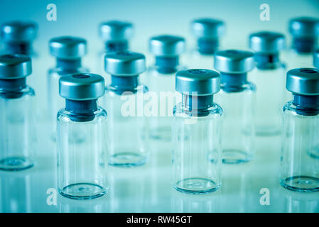 Gruppe von Impfstoff Glasflaschen auf blauem Hintergrund Stockfoto