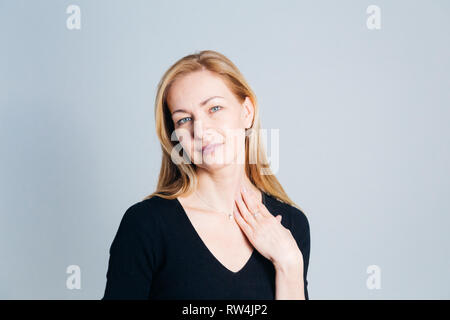 In der Nähe von Studio Portrait einer schönen Frau im schwarzen Kleid vor weißem Hintergrund Stockfoto