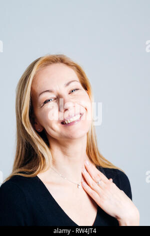 In der Nähe von Studio Portrait einer schönen Frau im schwarzen Kleid vor weißem Hintergrund Stockfoto