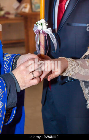 Traditionelle Trauung in der orthodoxen Kirche. Priester, Hochzeit Ring auf Braut Finger. Close Up. Stockfoto