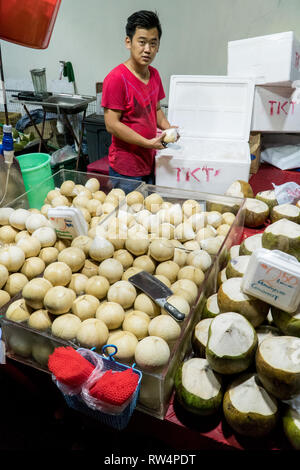 Singapur - Januar 28, 2019: - Verkäufer, frische junge Kokosnüsse in einer Straße Shop in China Town in Singapur Stockfoto