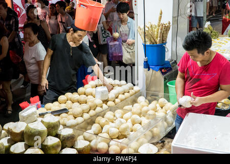 Singapur - Januar 28, 2019: - Verkäufer, frische junge Kokosnüsse in einer Straße Shop in China Town in Singapur Stockfoto