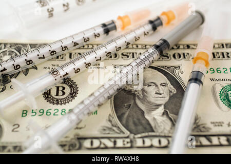 Close-up medizinische Spritzen auf einem US-Dollar Papier Währung Bank Note Stockfoto