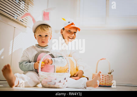 Zwei Brüder herausgeputzt für Ostern mit ihren Ostern Körbe Stockfoto