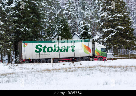 Stobart Truck, den das Fahrzeug entlang der A82 Straße am Tag der Winter mit Schnee um an Rannoch Moor, Glencoe, Highlands, Schottland im Winter Stockfoto
