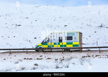 Rettungswagen Scottish Ambulance Service, den das Fahrzeug entlang der A82 Straße am Tag der Winter mit Schnee um an Rannoch Moor, Highlands, Schottland Stockfoto