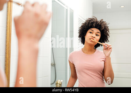 Reflexion einer jungen Frau im Spiegel die Zähne putzen Stockfoto