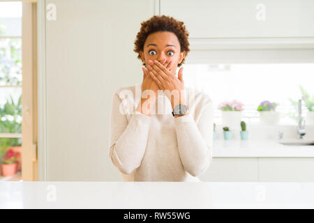 Junge schöne afrikanische amerikanische Frau zu Hause, die den Mund mit Händen für Fehler schockiert. Geheime Konzept. Stockfoto