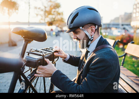 Hipster Geschäftsmann Pendler einrichten Fahrrad bei der Fahrt von der Arbeit nach Hause in die Stadt. Stockfoto
