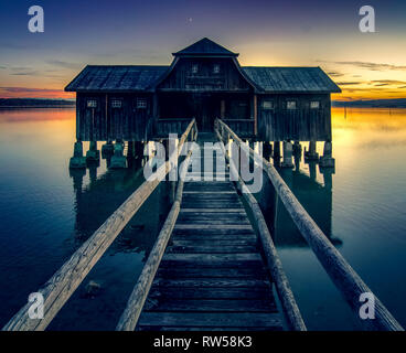 Mystic Holz- Bootshaus im See. Goldene Stunde Sonnenuntergang am bayerischen Ammersee, Deutschland Stockfoto