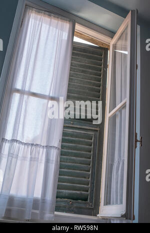 Eine halb offene Fenster mit Fensterläden von innen gesehen Stockfoto