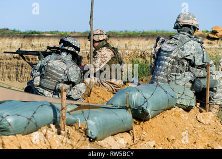 Us-Soldaten mit ihren Gewehren am Checkpoint sitzen. Stockfoto