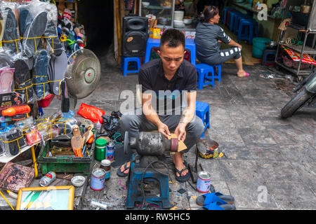 Mann bei der Arbeit als Schuster in den Straßen von Hanoi Old Quarter, Hanoi, Vietnam, Asien Stockfoto