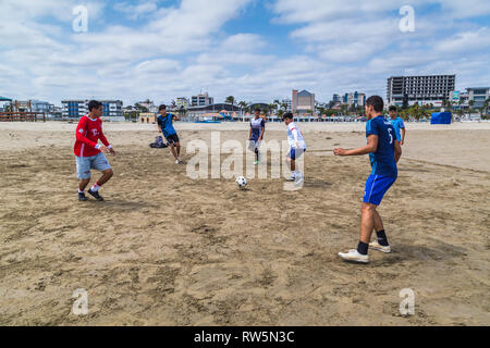 Manta, Ecuador, 28. September 2018: Eine Gruppe von unbekannten Studenten Fußball spielen am Strand, vor dem Unterricht, als Teil einer Gemeinde prog Stockfoto