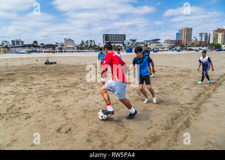 Manta, Ecuador, 28. September 2018: Eine Gruppe von unbekannten Studenten Fußball spielen am Strand, vor dem Unterricht, als Teil einer Gemeinde prog Stockfoto