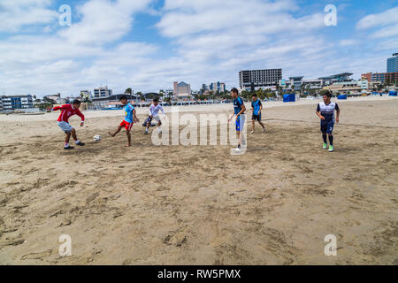 Manta, Ecuador, 28. September 2018: Eine Gruppe von unbekannten Studenten Fußball spielen am Strand, vor dem Unterricht, als Teil einer Gemeinde prog Stockfoto