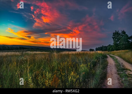 Sonnenuntergang über einem ländlichen Wanderweg im Tal Stockfoto