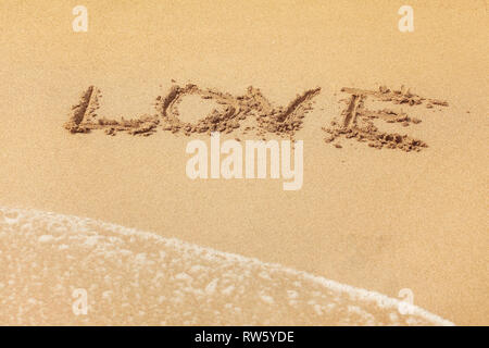 Wort Liebe in nassen Sand geschrieben am Strand, Sonne über scheint. Stockfoto